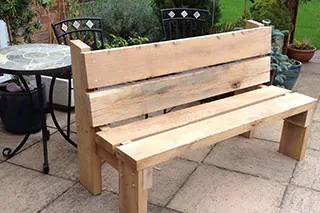 A chunky timber garden bench on a patio