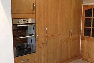 Wood-finish kitchen units with a built-in double oven